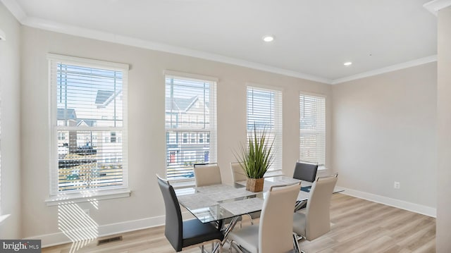 dining room featuring ornamental molding, light wood-type flooring, baseboards, and recessed lighting