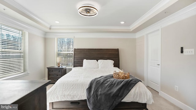 bedroom featuring multiple windows, a raised ceiling, and light colored carpet