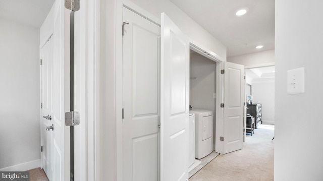 hallway with recessed lighting, light carpet, baseboards, and separate washer and dryer