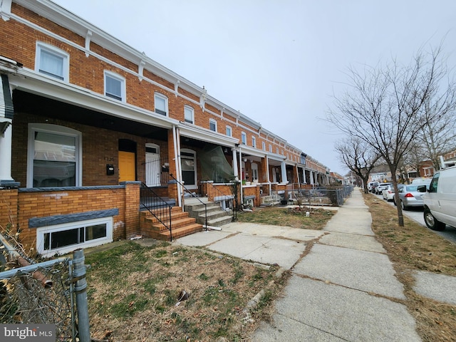 view of front of home with a porch and brick siding