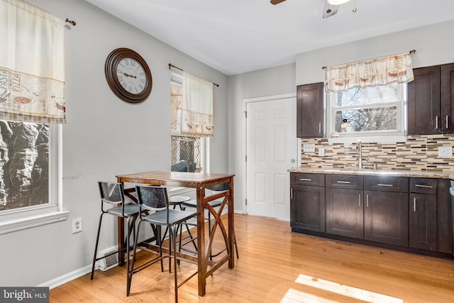 dining room featuring a ceiling fan, light wood-style flooring, and baseboards