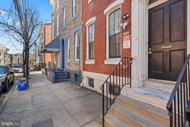 doorway to property featuring brick siding