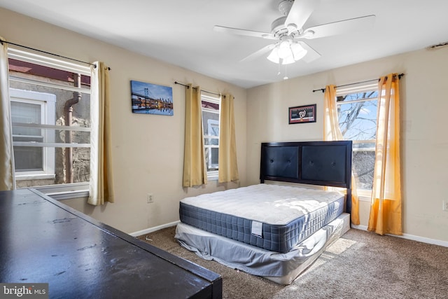 bedroom with a ceiling fan, carpet flooring, and baseboards