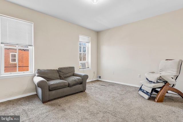 sitting room with cooling unit, visible vents, baseboards, and carpet flooring