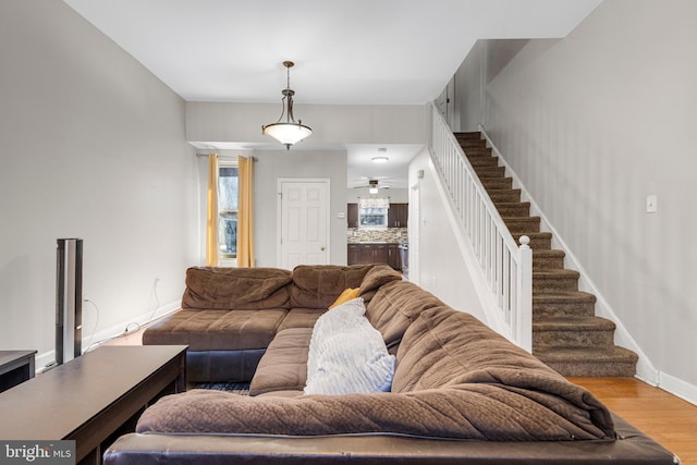 living room with stairway, baseboards, and wood finished floors