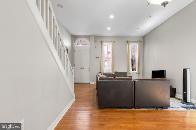 living area with stairway, recessed lighting, light wood-style flooring, and baseboards