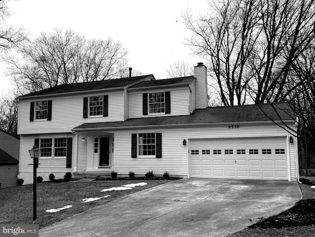 traditional-style home featuring a garage, driveway, and a chimney