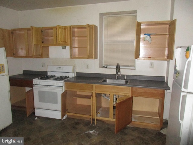 kitchen with dark countertops, white appliances, and a sink