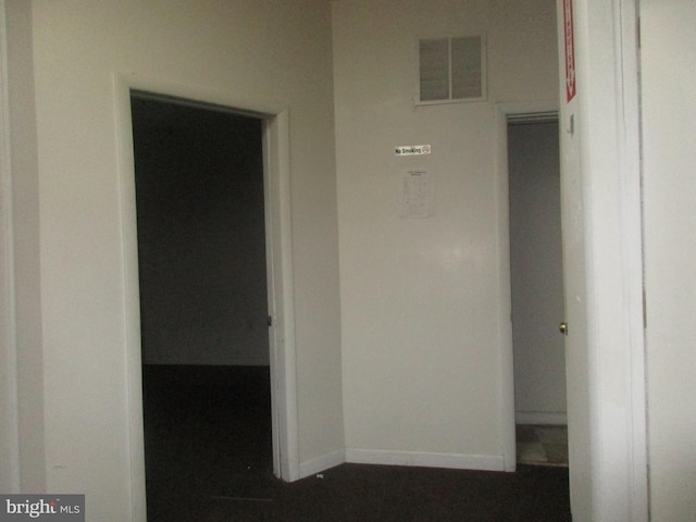 hallway with baseboards and visible vents