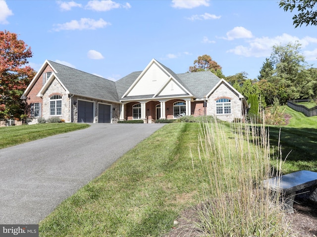 view of front facade with a garage, brick siding, driveway, and a front lawn