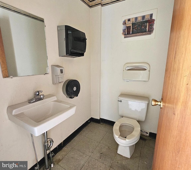 bathroom with tile patterned flooring, a sink, toilet, and baseboards