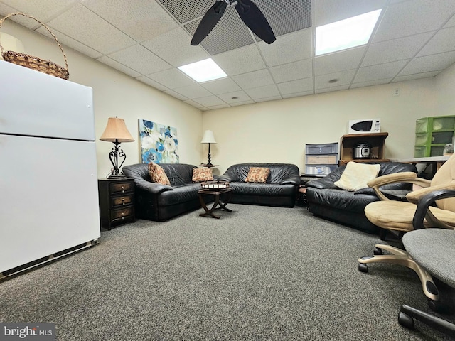 carpeted living area with a paneled ceiling