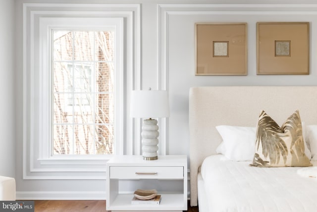 bedroom with baseboards and wood finished floors