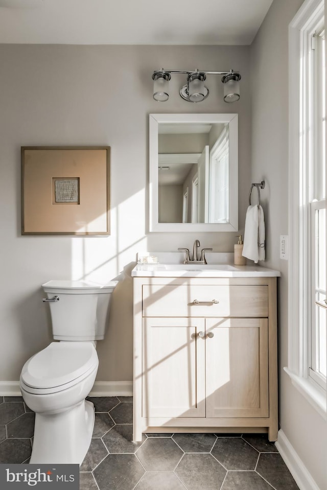 bathroom featuring tile patterned floors, baseboards, toilet, and vanity