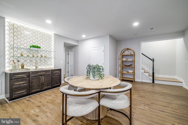 dining area with light wood-type flooring, visible vents, recessed lighting, and stairs