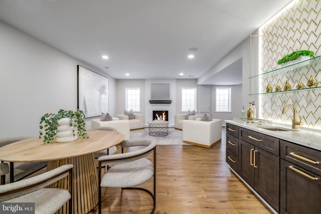 interior space featuring recessed lighting, a lit fireplace, and light wood-style flooring