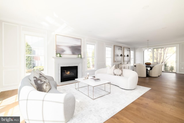 living room with a decorative wall, a healthy amount of sunlight, and wood finished floors