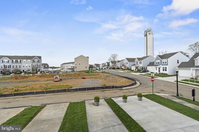 view of road featuring traffic signs, sidewalks, and a residential view