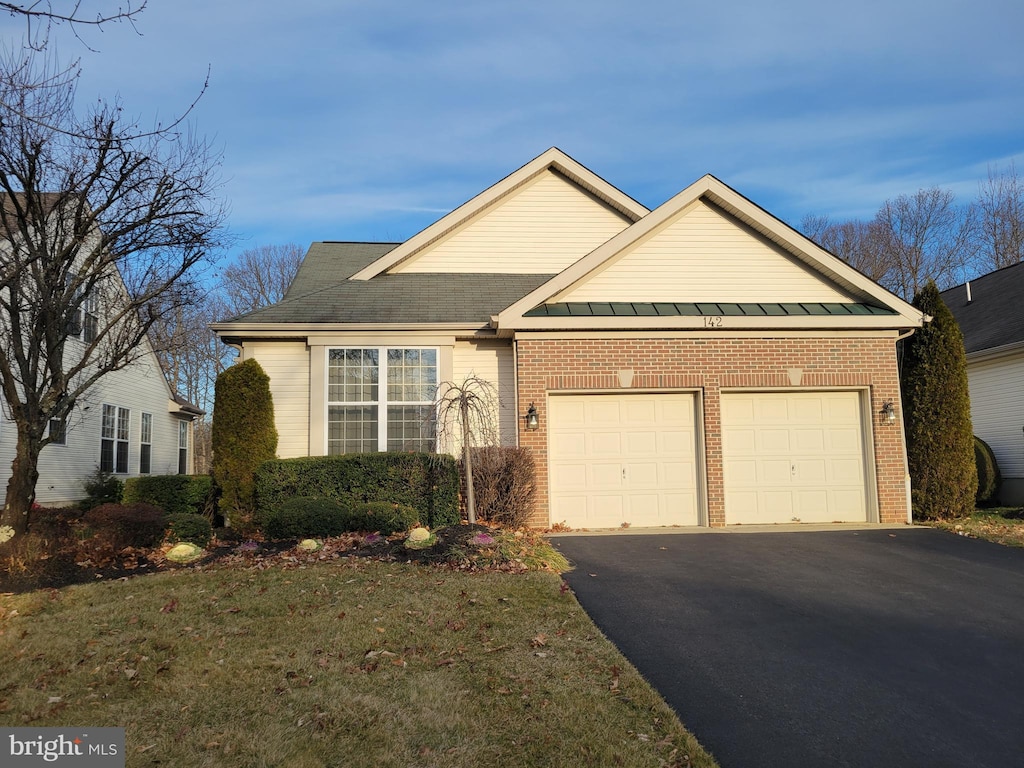 single story home featuring brick siding, driveway, and an attached garage