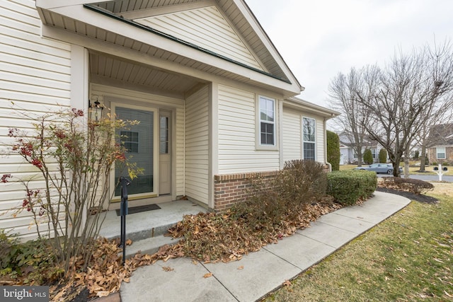 view of exterior entry with brick siding