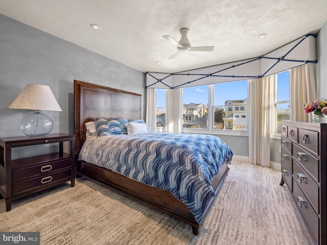 bedroom featuring a ceiling fan, light colored carpet, and baseboards