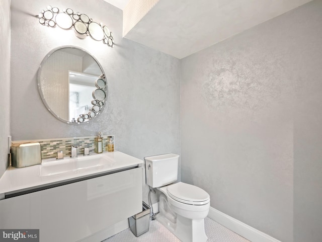 half bath with tasteful backsplash, baseboards, vanity, and toilet