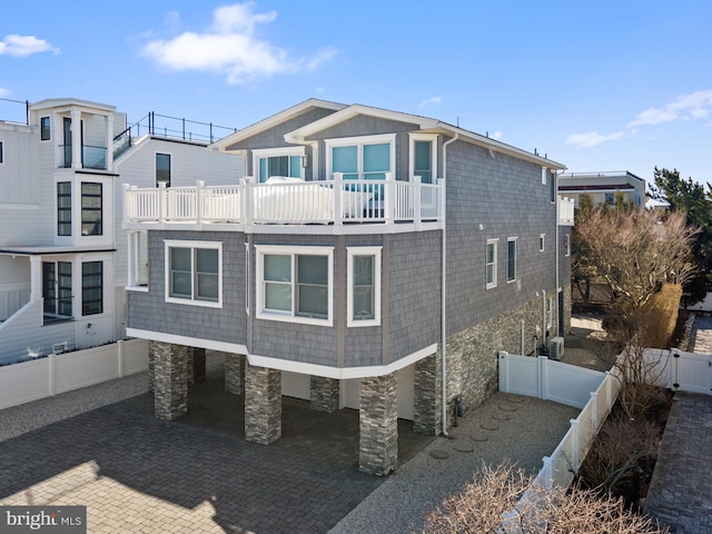 rear view of house with a gate, a fenced backyard, a patio, and a balcony