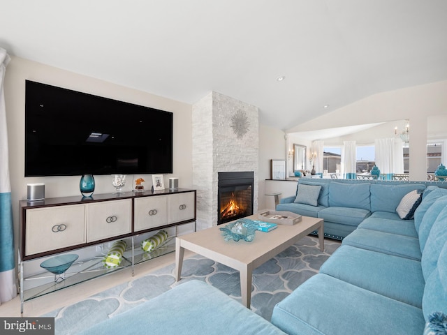 living area featuring vaulted ceiling and a stone fireplace