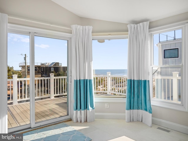 entryway featuring vaulted ceiling, a water view, visible vents, and baseboards