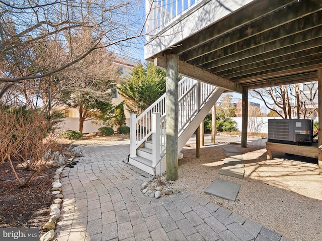 view of patio featuring stairs, fence, and central AC unit