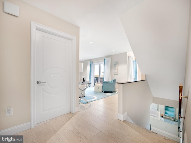 hall with recessed lighting, an upstairs landing, and baseboards