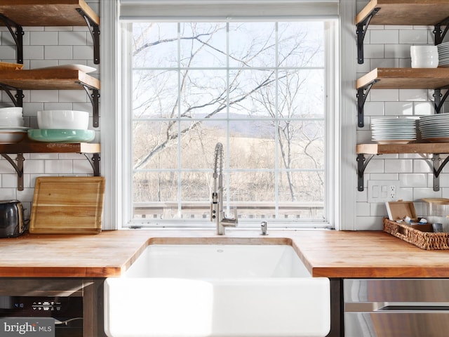 interior space with butcher block countertops and a sink