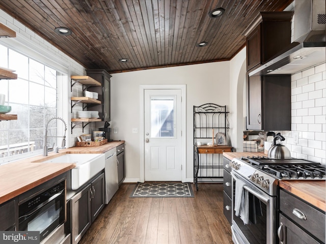 kitchen with butcher block counters, gas stove, wood ceiling, wall chimney range hood, and dishwasher