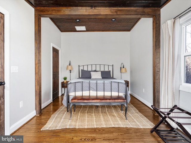 bedroom featuring wooden ceiling, wood finished floors, and baseboards