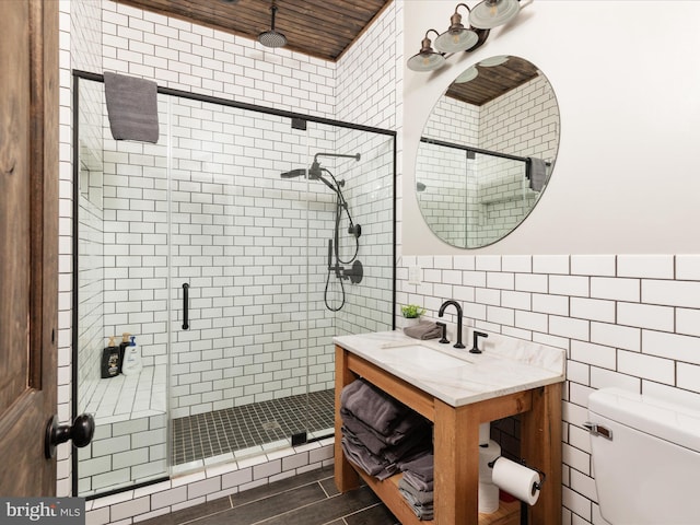 bathroom featuring toilet, a shower stall, tile walls, and vanity