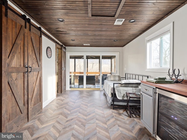 kitchen with beverage cooler, wood counters, a wealth of natural light, and a barn door