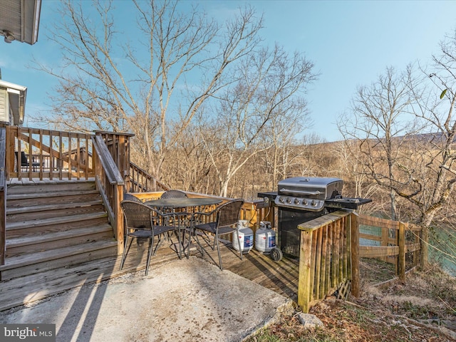 view of patio with a grill, stairway, outdoor dining area, and a wooden deck