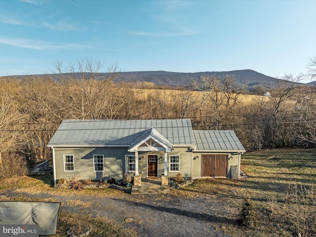 view of front of property with metal roof, a standing seam roof, and a mountain view