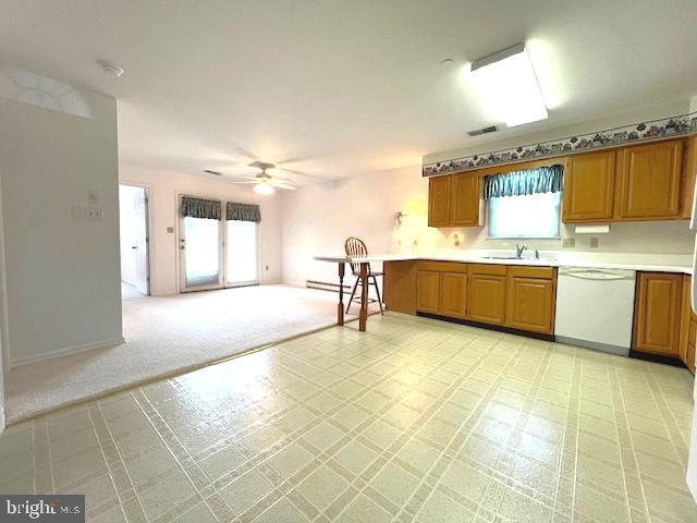 kitchen featuring a wealth of natural light, visible vents, open floor plan, a sink, and dishwasher