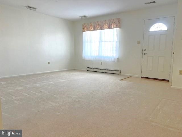 entryway featuring light carpet, visible vents, and baseboard heating