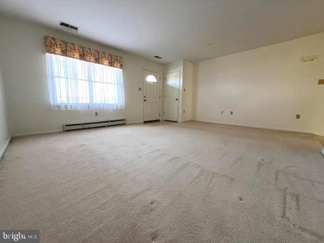 unfurnished living room featuring a baseboard radiator, visible vents, baseboards, and light colored carpet