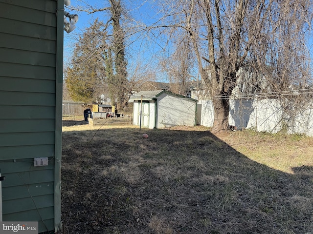 view of yard with a shed, an outdoor structure, and fence