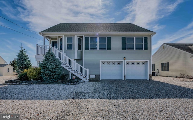 view of front of house featuring gravel driveway, an attached garage, stairs, and a shingled roof