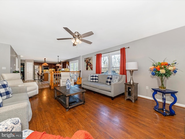 living area with ceiling fan, baseboards, and wood finished floors