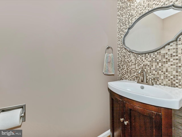 bathroom with baseboards, backsplash, and vanity