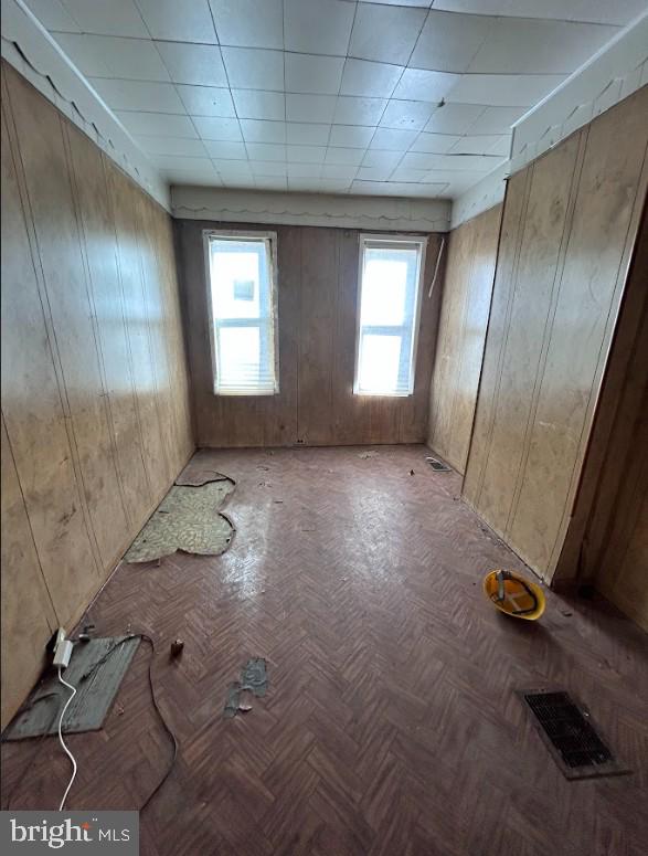 spare room featuring visible vents and wooden walls