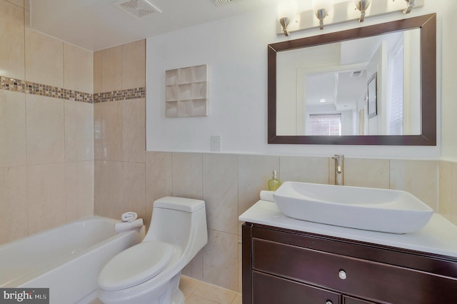 bathroom featuring toilet, vanity, visible vents, and tile walls