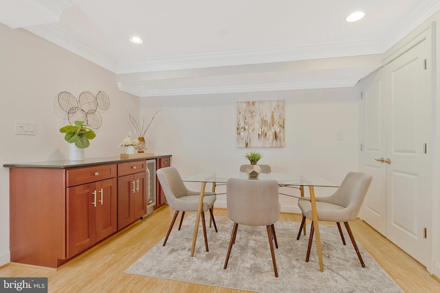 dining space with ornamental molding, light wood-type flooring, recessed lighting, and wine cooler