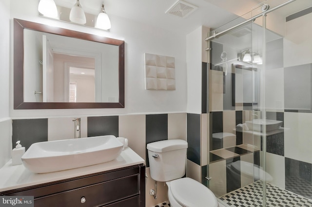 full bathroom featuring a stall shower, visible vents, vanity, and toilet