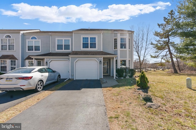 view of property featuring a front yard, a garage, and driveway